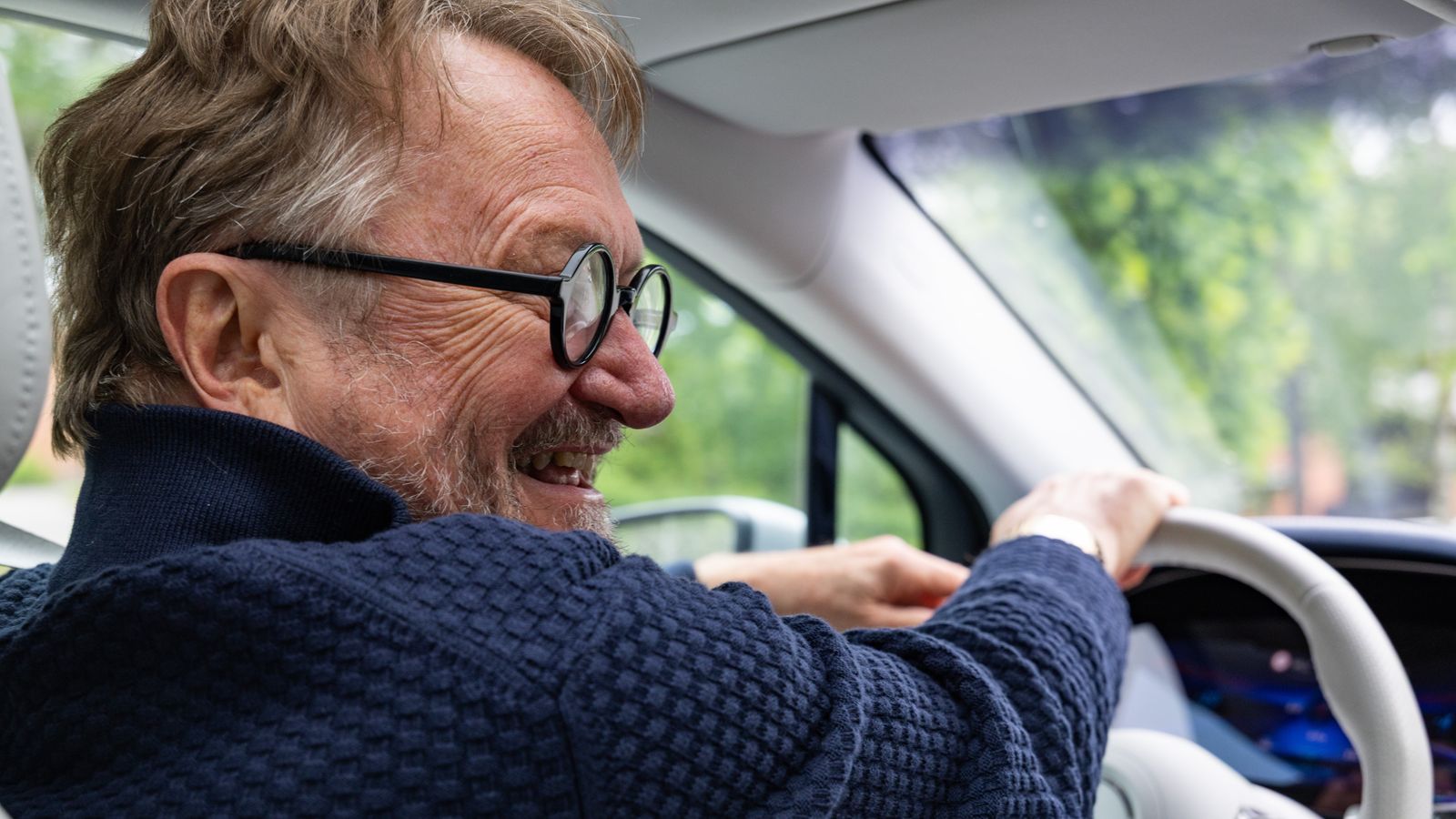 Sijoittaja Schrey hymyilee autonsa ratissa